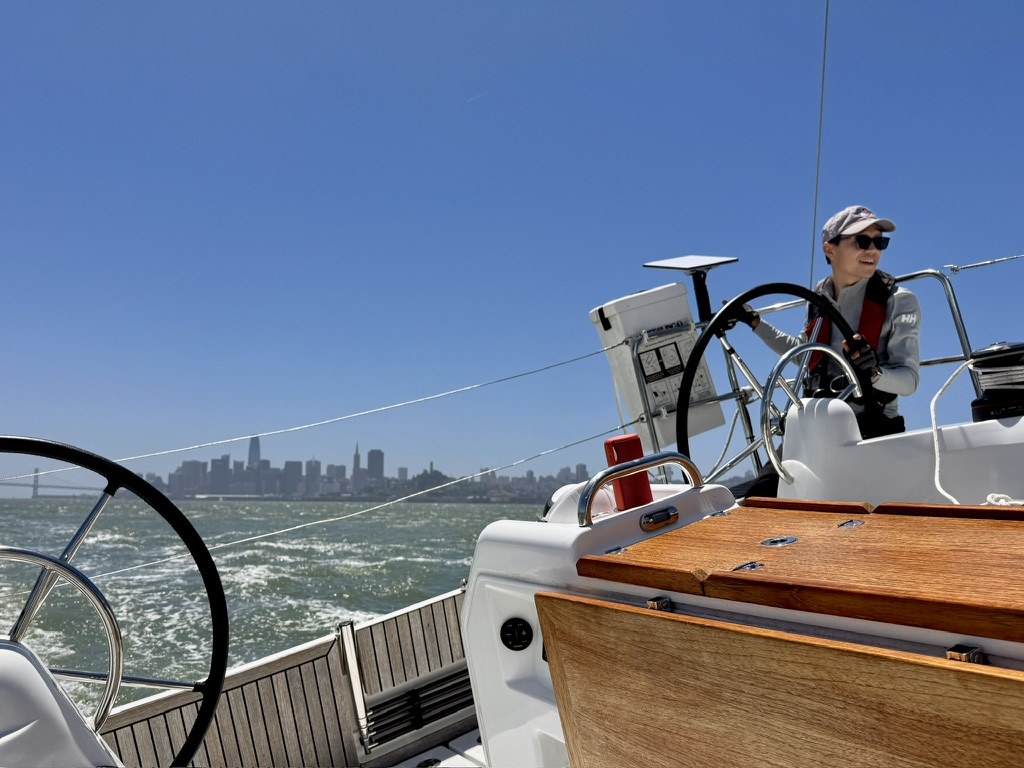Bo at the helm of a sailboat on San Francisco Bay
